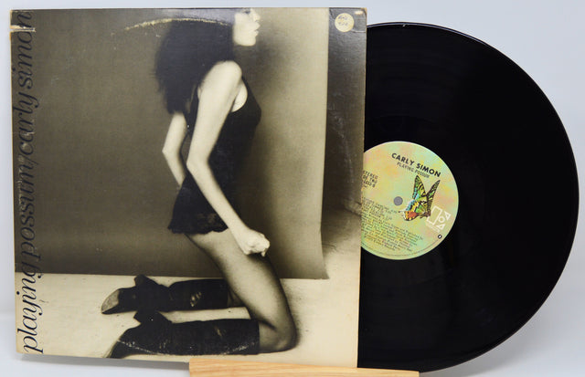 Vinyl record with a cover featuring a woman and a butterfly, on a light gray background.