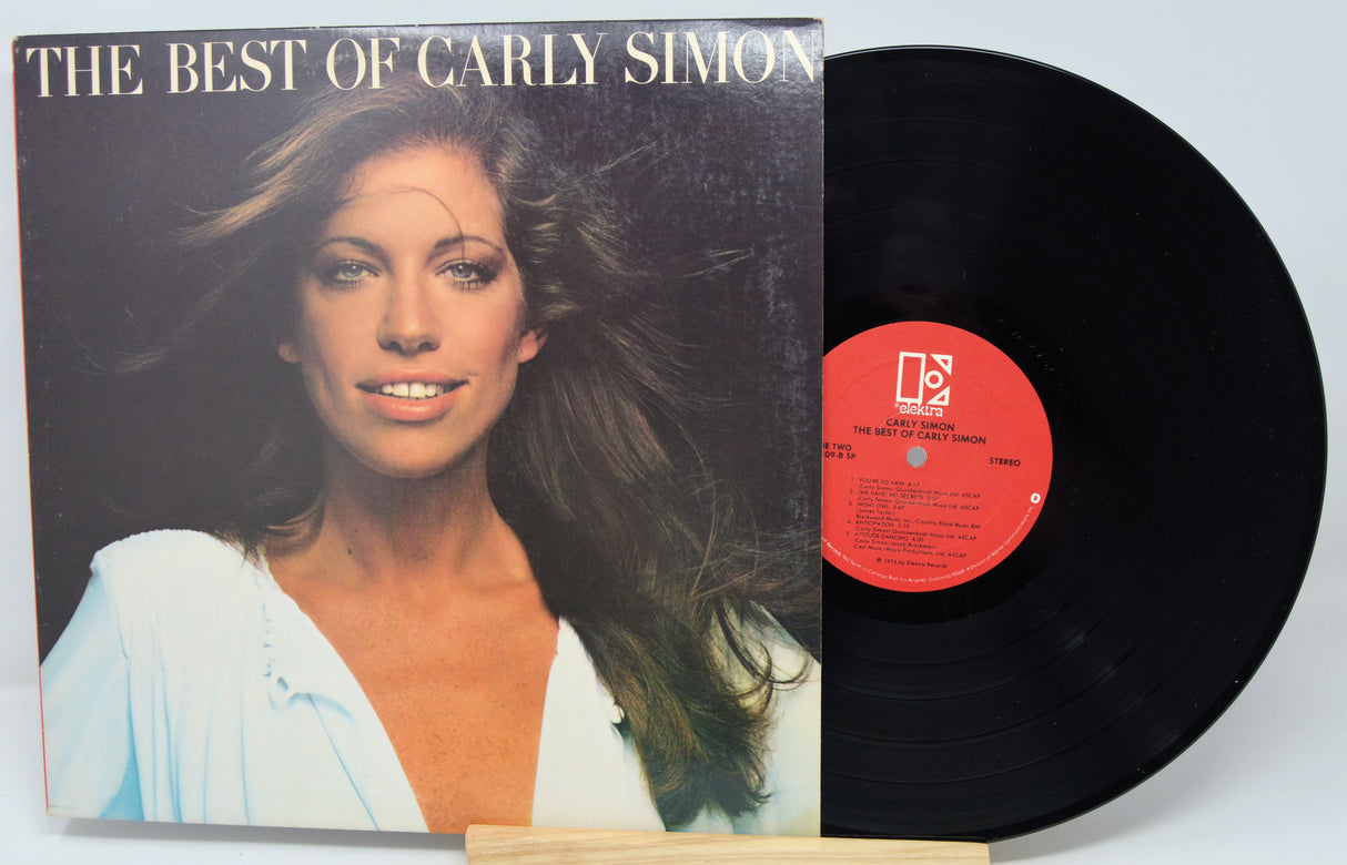Vinyl record and cover titled 'The Best of Carly Simon' on a light blue background