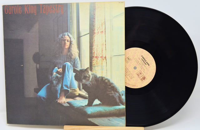 Vinyl record with cover featuring a person and cat, titled 'Tapestry' by Carole King.