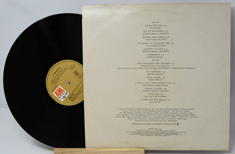 Vinyl record with a white label showing track listings on a light gray background