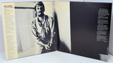 Album cover with a black and white photo of a person on the left and text on the right.