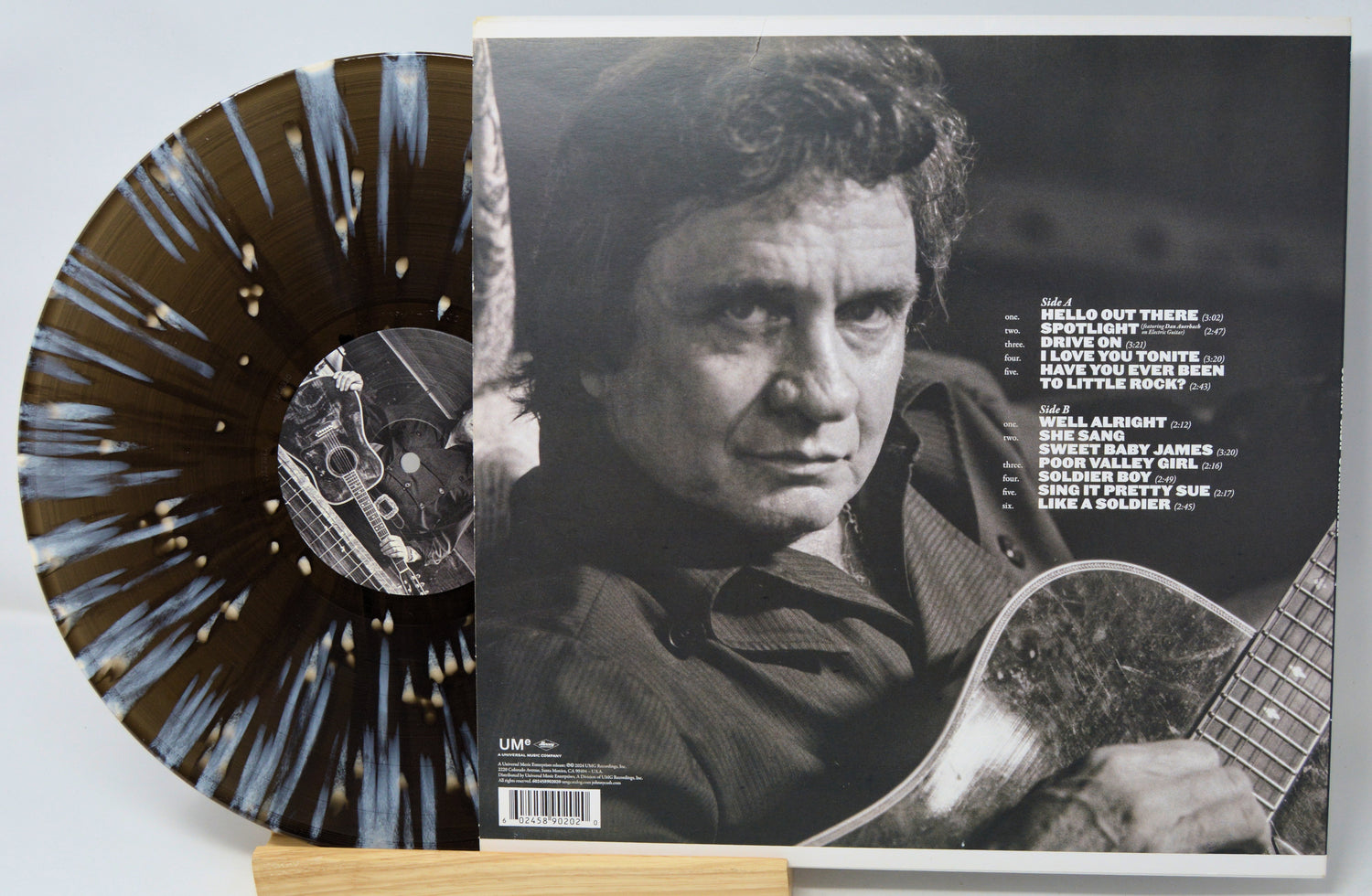 Vinyl record with a black and white photo of a person holding a guitar on the cover