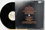 A vinyl record partially pulled from its sleeve, showing the black record and the black album cover with orange and white text listing track titles.