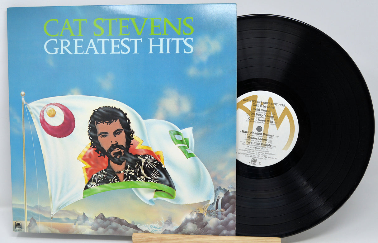 Vinyl record with 'Cat Stevens Greatest Hits' cover featuring a man and flag design.