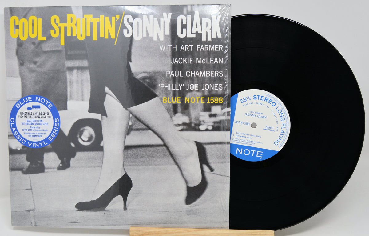 Cool Struttin' / Sonny Clark vinyl record album shown with the printed cover in front and the black vinyl record partially visible behind it on a small wooden stand.
