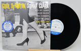 Cool Struttin' / Sonny Clark vinyl record album shown with the printed cover in front and the black vinyl record partially visible behind it on a small wooden stand.