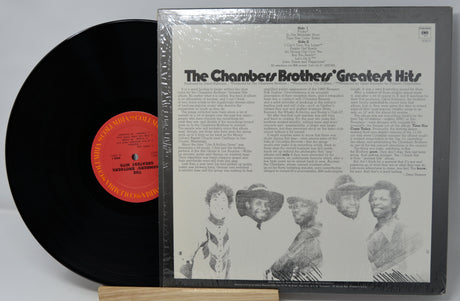Vinyl record and cover of 'The Chambers Brothers' Greatest Hits' on a gray background