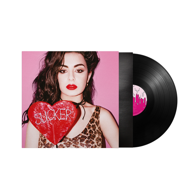 A vinyl record partially pulled from its sleeve, showing the album cover art of a woman holding a red heart with the word 'SUCKER' on a black background.