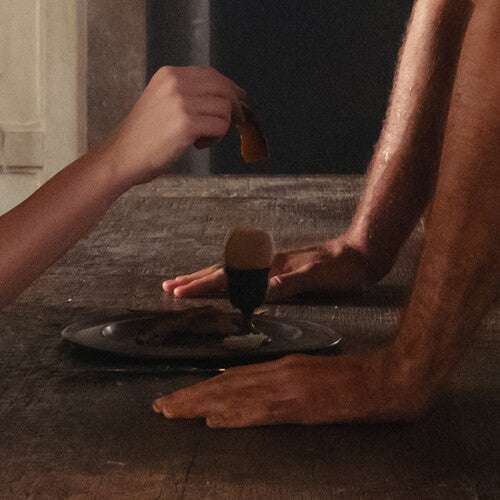Close-up of a person applying a cosmetic product to their arm with a brush on a textured surface.