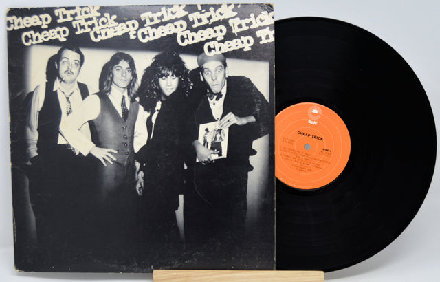 Vinyl record with a black and white cover featuring a band and an orange label.