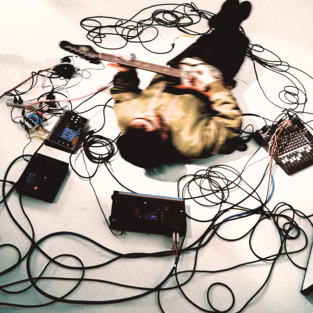 Guitar with electronic equipment and cables on a light background
