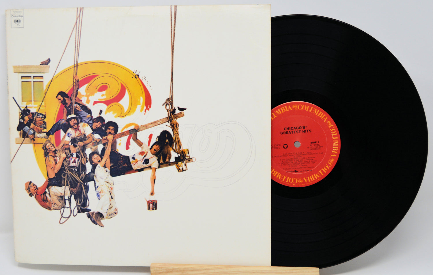Vinyl record with a colorful cover featuring people on a boat and a red label.