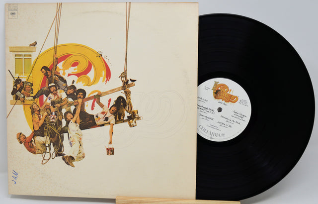 A vinyl record partially pulled from its sleeve, showing the album cover artwork and a black record on a light gray background.