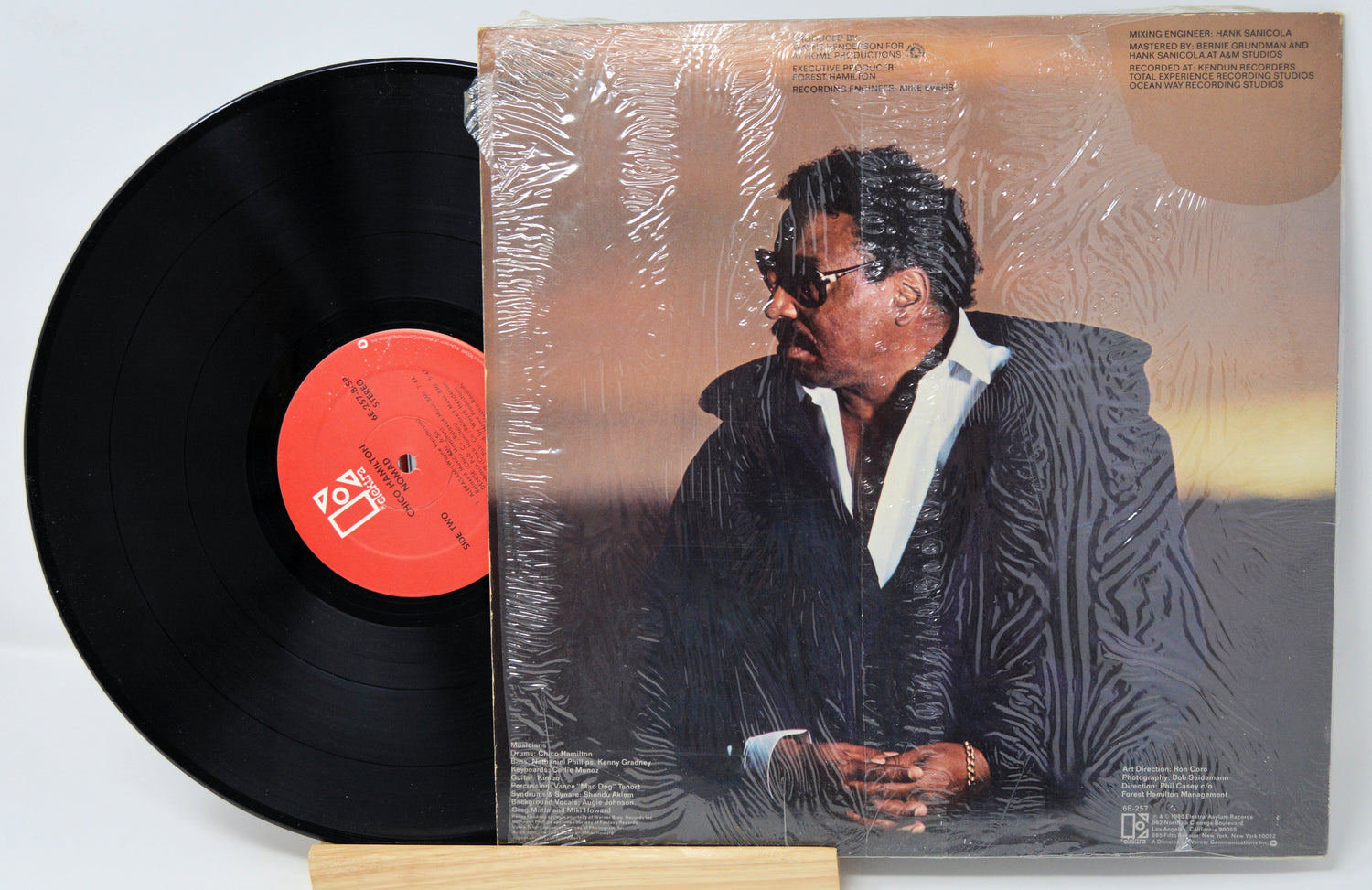 Vinyl record with cover featuring a person, on a light gray background