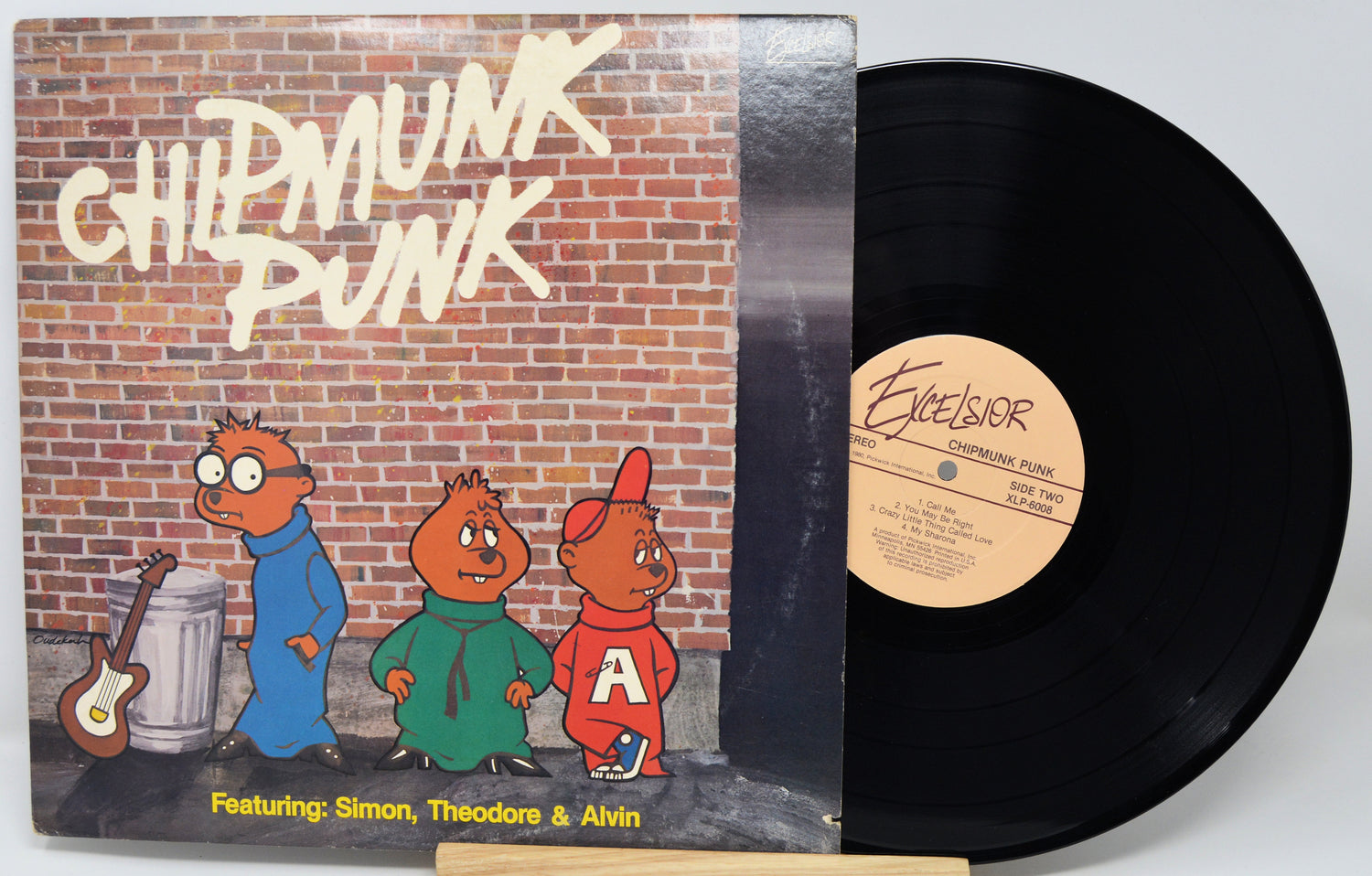 Vinyl record with cartoon characters on the cover against a brick wall background