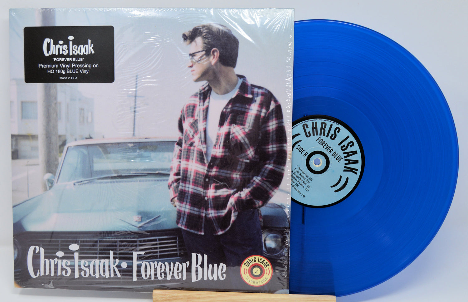 Blue vinyl record with Chris Isaak in plaid shirt and car, featuring Chris Isaak's 'Forever Blue' album.