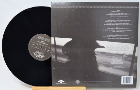 Vinyl record with cover displaying text and a silhouette of a person.