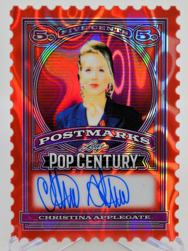 Collectible card with a stylized portrait of a woman, 'Postmarks Pop Century', and 'Christina Applegate' signature on a red and purple background.
