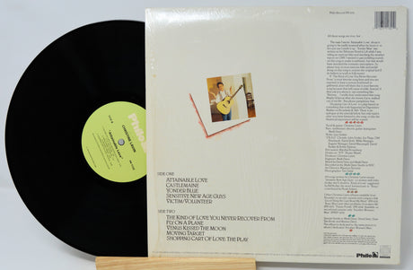 Vinyl record with green label and cover showing a person playing guitar.