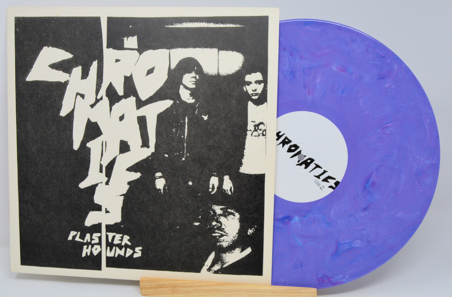 Front cover of Chromatics Plaster Hounds album featuring band photo and purple vinyl