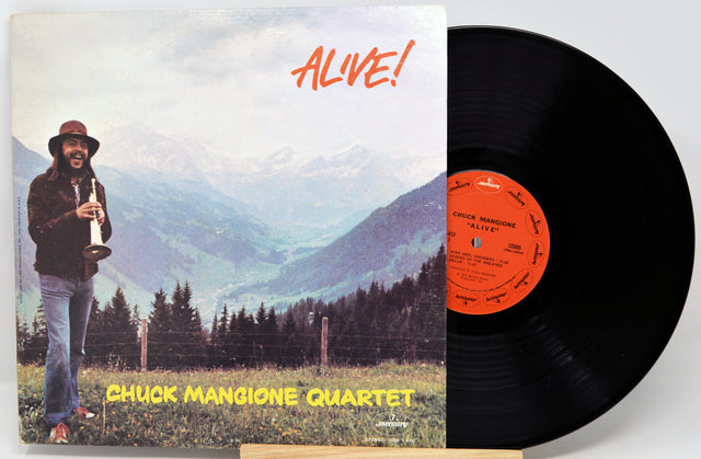 Vinyl record and cover of 'Alive!' by Chuck Mangione Quartet with a mountainous landscape.