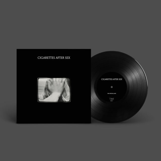 Vinyl record and cover with 'Cigarettes After Sex' branding on a gray background