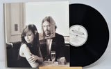 Vinyl record with a black and white cover featuring two people at a table.