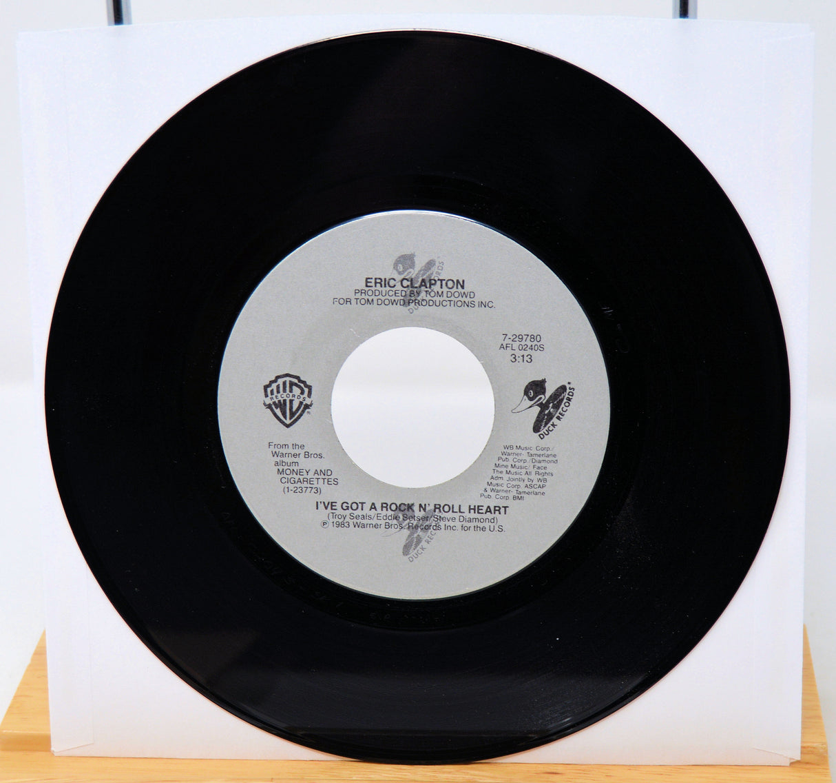 Vinyl record with a white label featuring text and logos on a white background