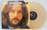 Vinyl record with cover featuring a portrait of Eric Clapton on a white background