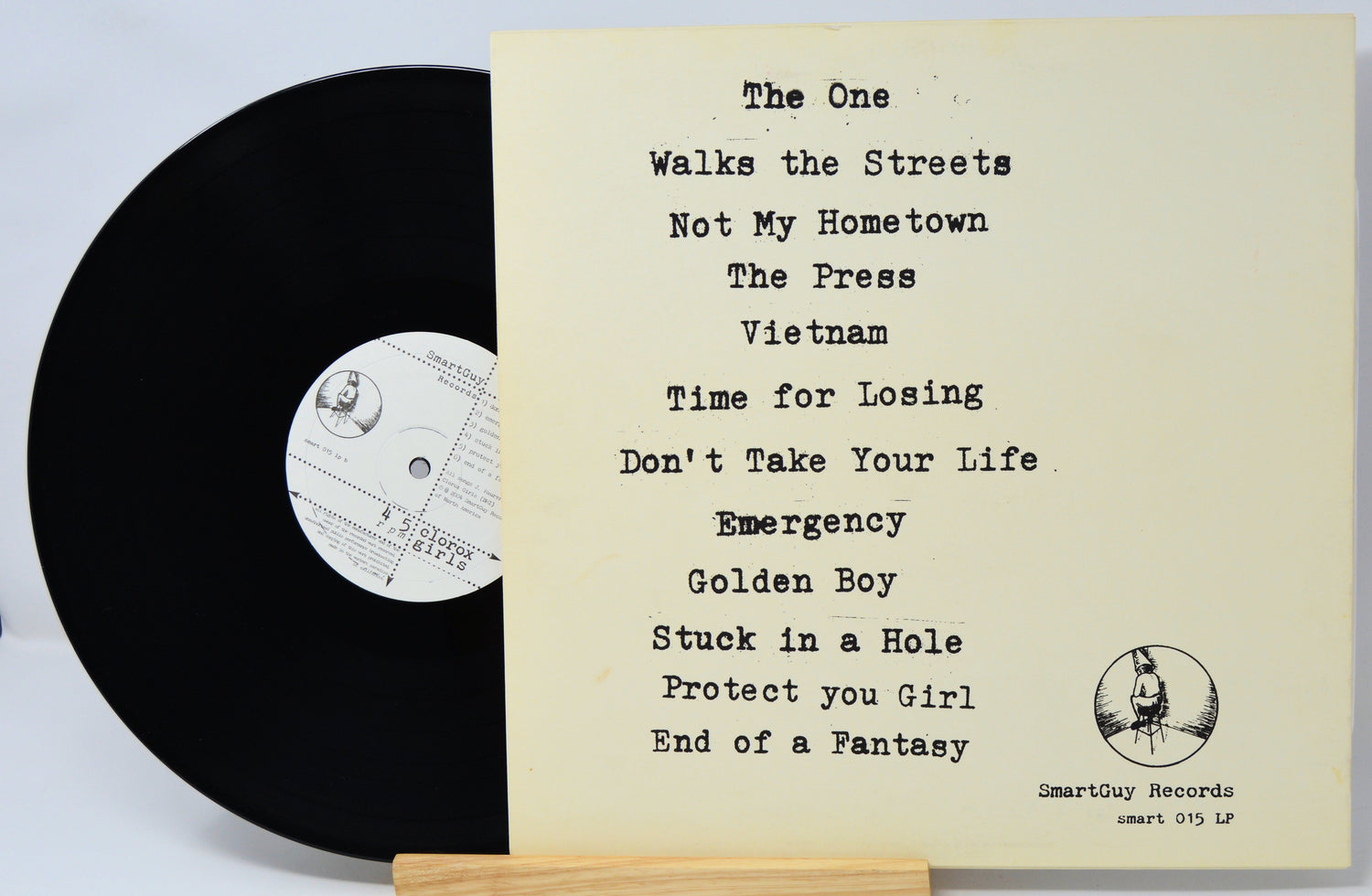Vinyl record with a list of song titles on a stand against a light background