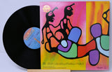 Vinyl record with colorful cover featuring abstract human figures on a white background