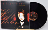 Holly Cole 'Temptation' vinyl record album with the LP partially pulled from the jacket, photographed on a light gray background.