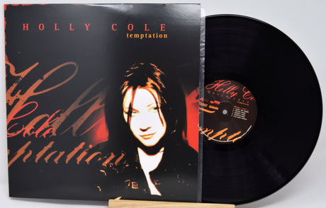 Holly Cole 'Temptation' vinyl record album with the LP partially pulled from the jacket, photographed on a light gray background.