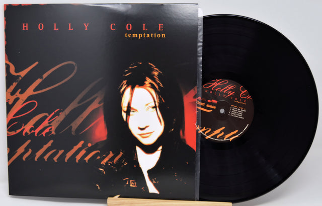 Holly Cole 'Temptation' vinyl record album with the LP partially pulled from the jacket, photographed on a light gray background.