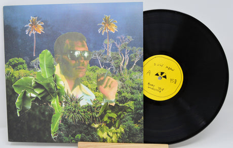 Vinyl record with jungle-inspired collage cover art of a man in sunglasses with tropical foliage and palm trees