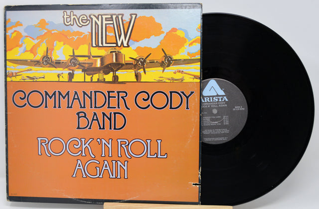 Vinyl record with 'The New Commander Cody Band Rock 'N Roll Again' album cover featuring an airplane illustration.
