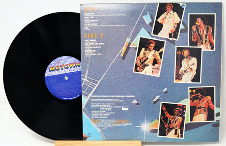 Vinyl record with a blue label and a cover featuring images of a musician on a white background