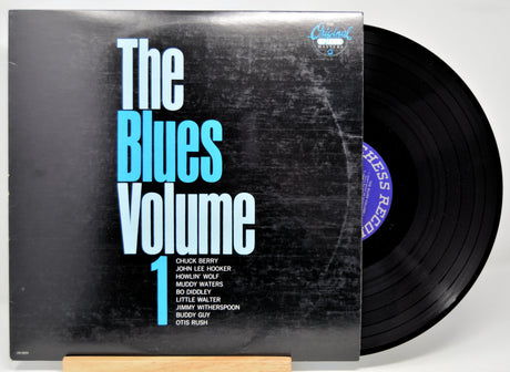 Vinyl record with 'The Blues Volume 1' cover featuring a distressed texture.