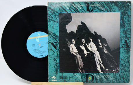 Vinyl record with a cover featuring a black and white photo of four people against a mountainous background.