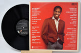 Vinyl record with a red cover featuring a man in a suit on a white background