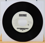 Vinyl record with a white label featuring 'Coolio' on a wooden surface.