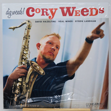 A vinyl record sleeve for Cory Weed's 'dig weedz!' album, featuring a photo of the saxophonist pointing while holding a saxophone. The sleeve is wrapped in clear plastic, and the Coherent Records logo is visible in the bottom right corner.