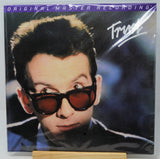 A vinyl record sleeve for Trust's 'Original Master Recording' album, featuring a close-up portrait of the artist wearing dark sunglasses, displayed on a small wooden stand.