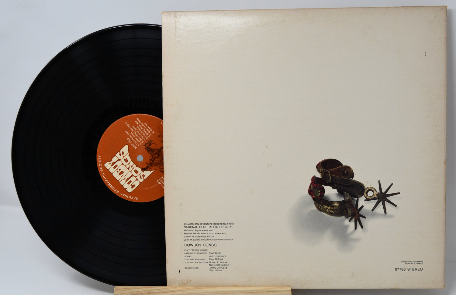 Cowboy Songs vinyl record partially out of cream album cover with spurs illustration