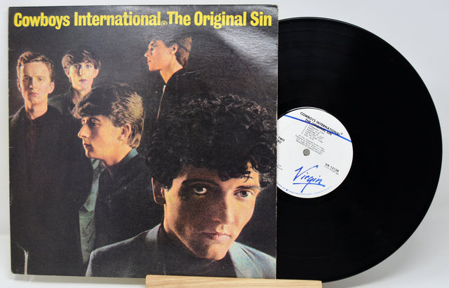 Vinyl record with cover featuring a group of people, labeled 'Cowboys International. The Original Sin'.