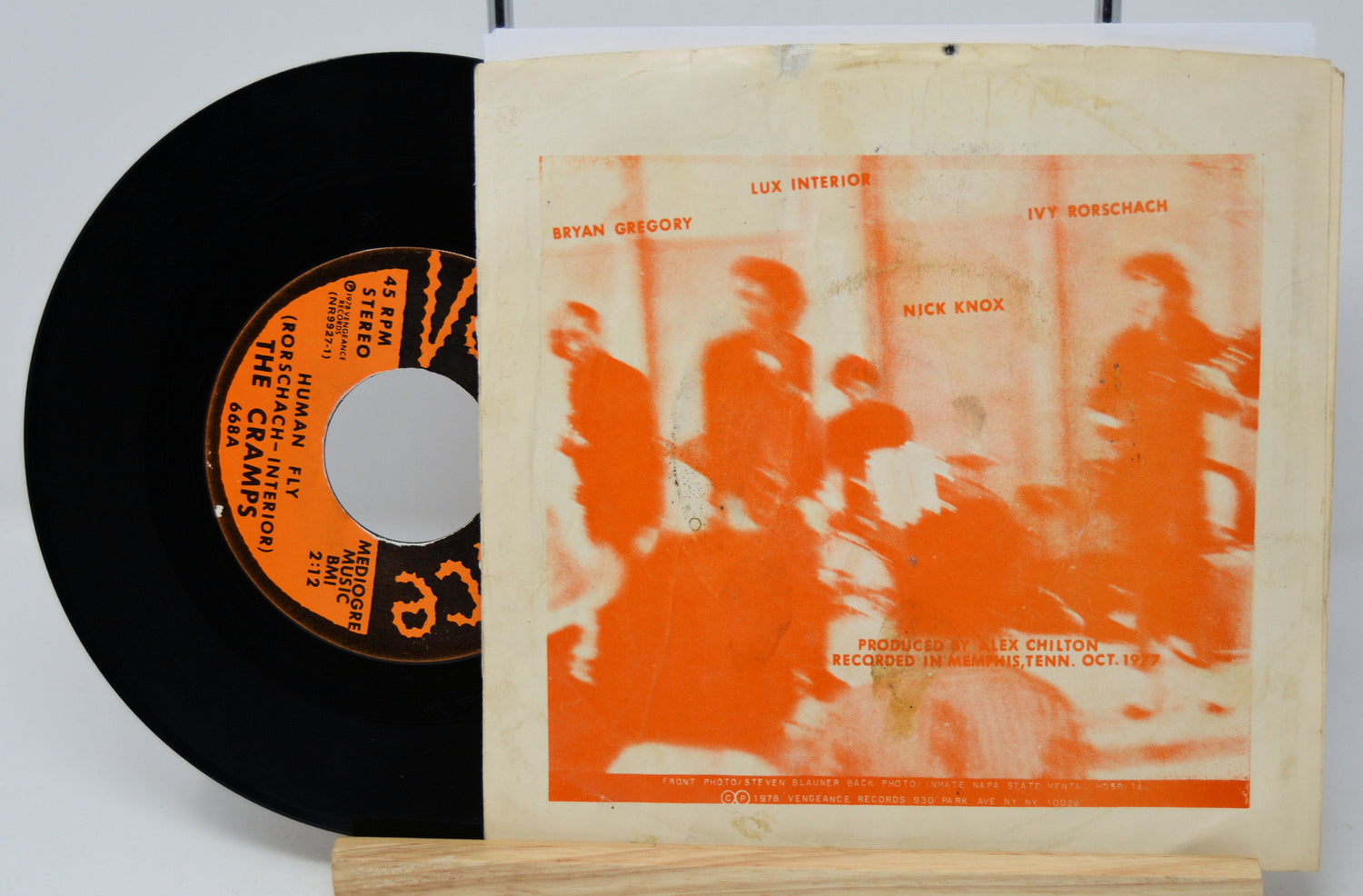 Vinyl record with orange cover featuring silhouettes of people and text.