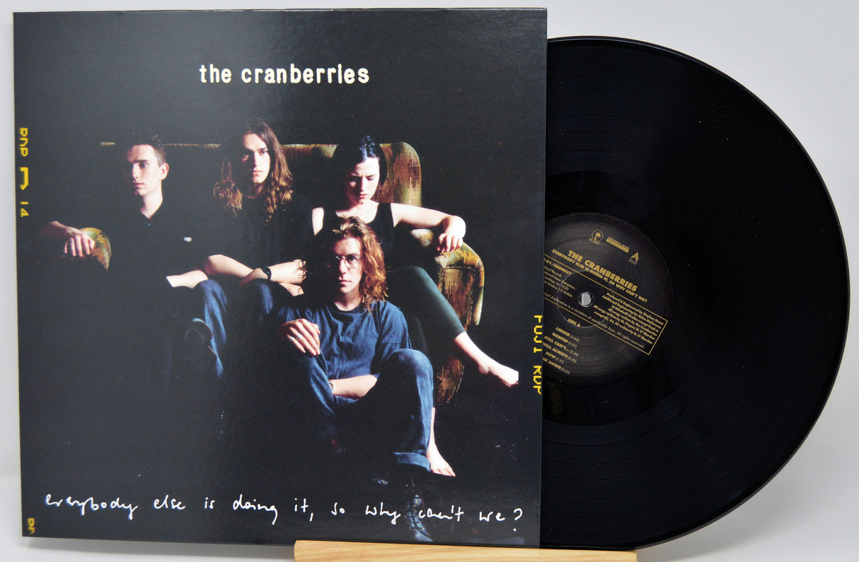 The Cranberries 'Everybody Else Is Doing It, So Why Can't We?' vinyl record LP with its black cover jacket and a partially visible black record on a light gray background.