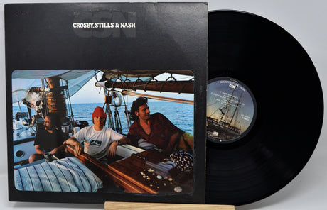 Crosby, Stills & Nash 'On A Sailboat' vinyl record LP with the black record partially pulled from its black sleeve, which features a color photo of the band on a sailboat.