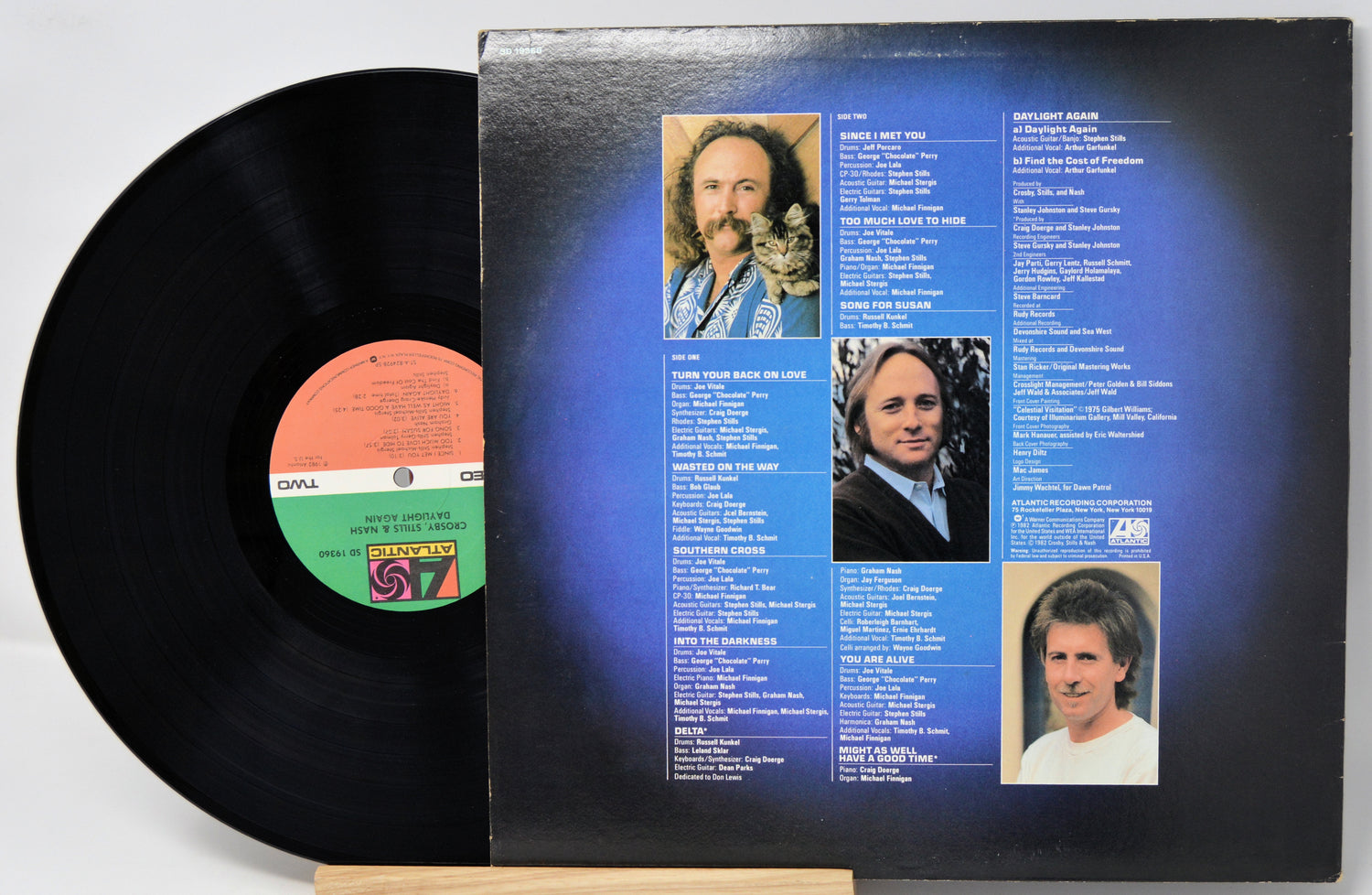 Vinyl record with cover featuring album tracklist and portraits on a white background