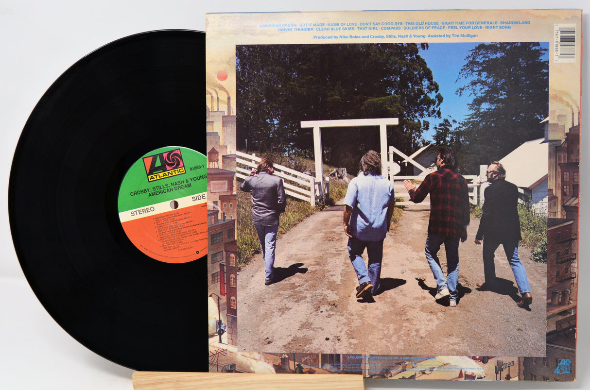 Vinyl record with a cover showing four people walking towards a wooden gate.